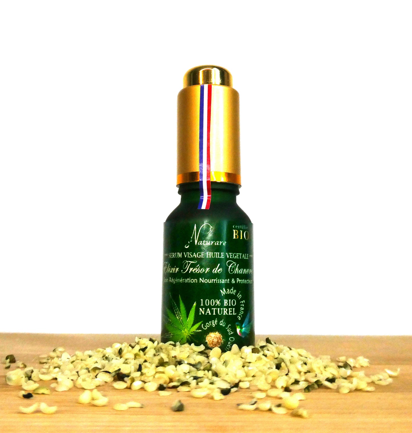 Agnès' Petit Paris Skincare organic French facial serum in green bottle with gold cap on wooden surface