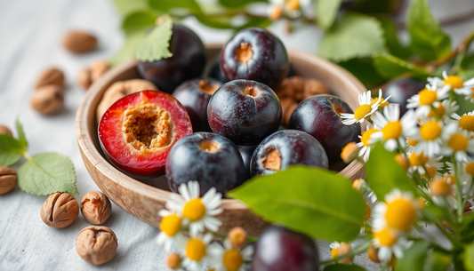 Bowl of fresh plums with herbs and chamomile flowers representing natural ingredients for Eco Cert French Skincare