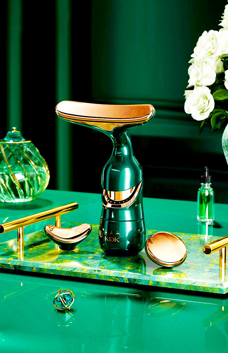 Delphy-triple head facial massager by Agnès Petit Paris Skincare in green and gold on a marble tray