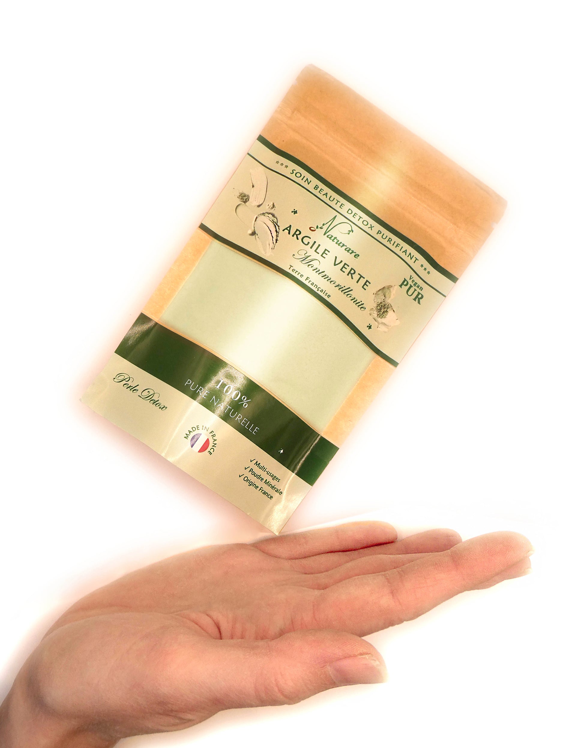 package of French green clay for detox held above open hand, natural organic skincare product