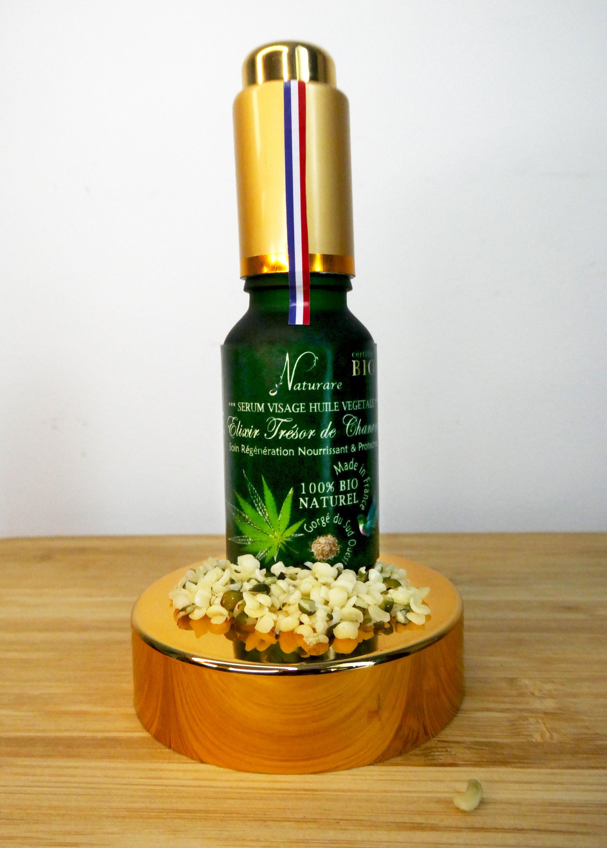 Naturare.fr anti-aging serum bottle labeled French natural skincare elixir on gold pedestal with natural ingredients