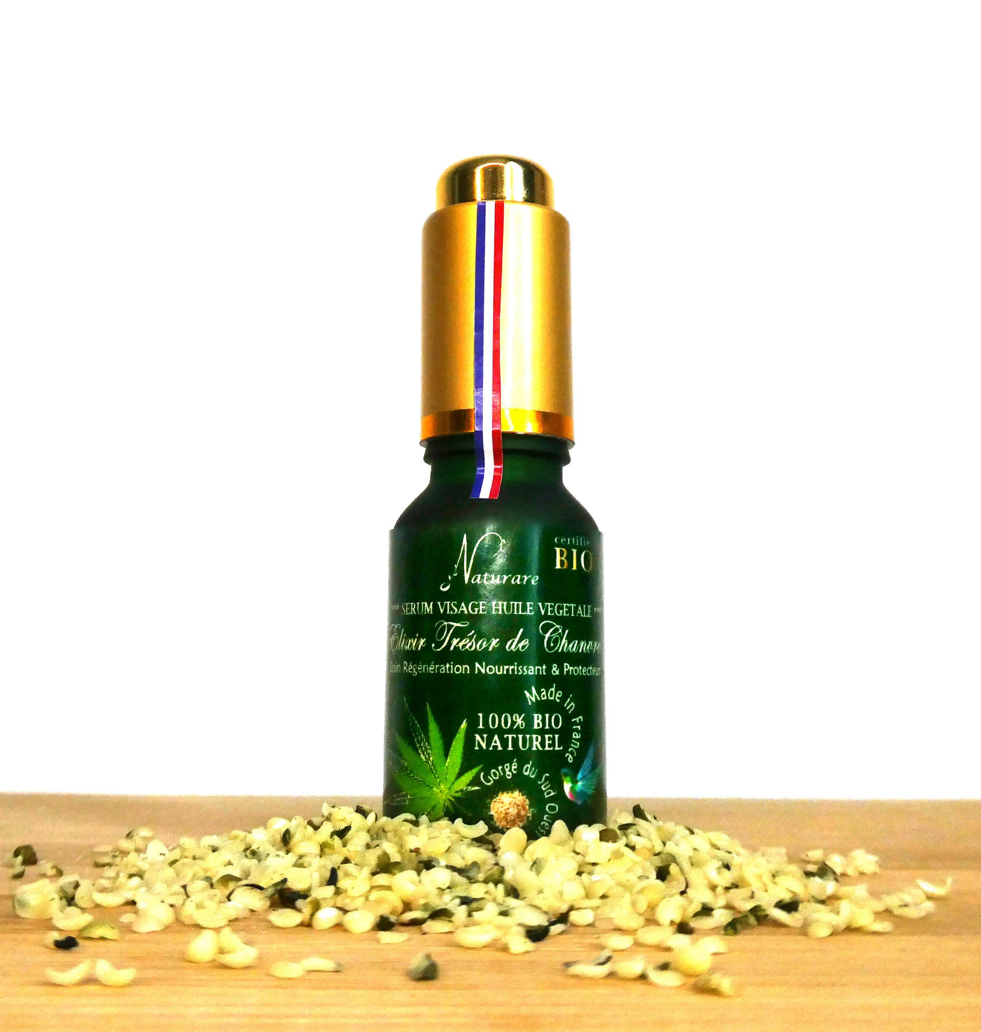 Agnès' Petit Paris Skincare organic French facial serum in green bottle with gold cap on wooden surface