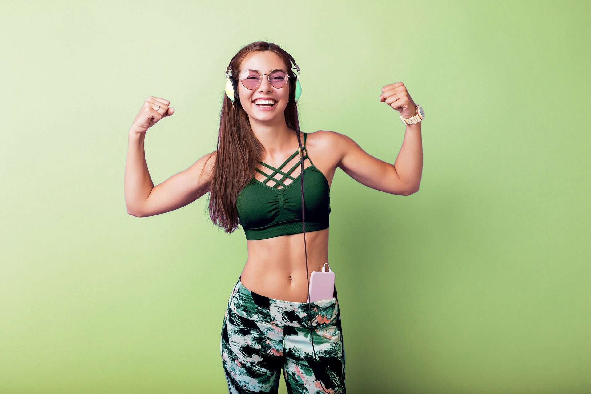 Happy young woman in workout clothes showing strength, promoting organic Klamath supplement benefits